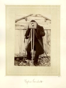 Fotograf med klede over hodet, bak et kamera på stativ - Norsk folkemuseum - NF.15006-001