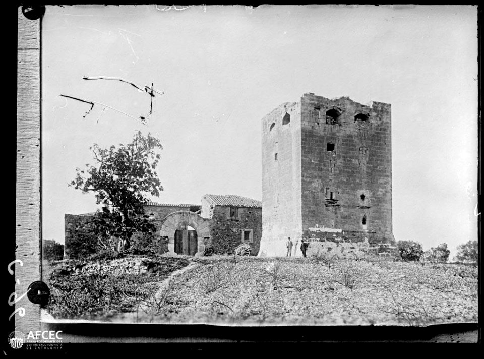 Fotografia d'una antiga torre de defensa de Barenys reconvertida en casa de pagès amb dos homes al davant