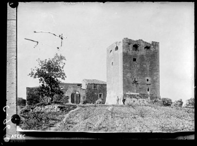 Fotografia d'una antiga torre de defensa de Barenys reconvertida en casa de pagès amb dos homes al davant