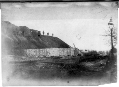 Four men on a hill overlooking a construction site with a lamp post LCCN2002718269