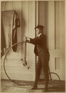 Frances Benjamin Johnston, full-length self-portrait dressed as a man with false moustache, posed with bicycle, facing left LCCN2001697163