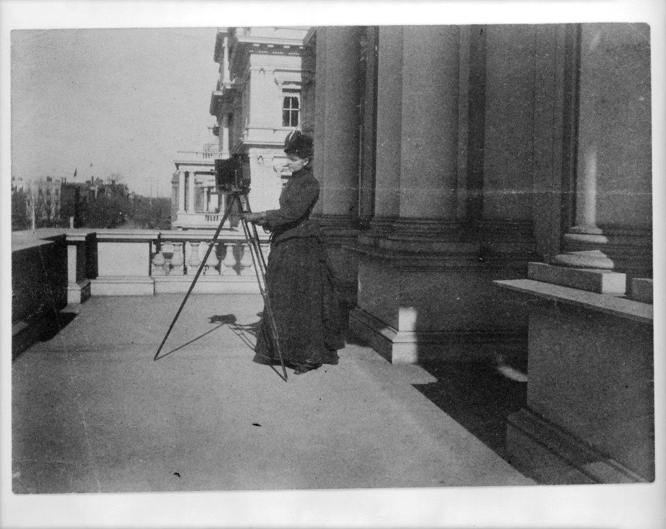 Frances Benjamin Johnston with camera on balcony of State, War and Navy Building (now the Dwight D. Eisenhower Executive Office Building), Washington, D.C., 1888 LCCN96510212