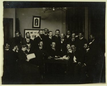 Frances Benjamin Johnston, seated in profile at left, group portrait with 18 unidentified men LCCN2001697160 photo