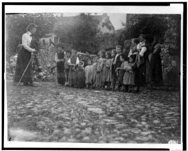 Frances Benjamin Johnston photographing a group of people, mostly children, in Europe LCCN98509536 photo
