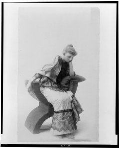 Frances Benjamin Johnston, full-length portrait, seated, facing left, looking downward, resting her head on her left hand LCCN98506468 photo