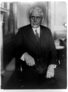 Frank Billings Kellogg, three-quarter length portrait, seated, facing left, holding eyeglasses LCCN96508557 photo