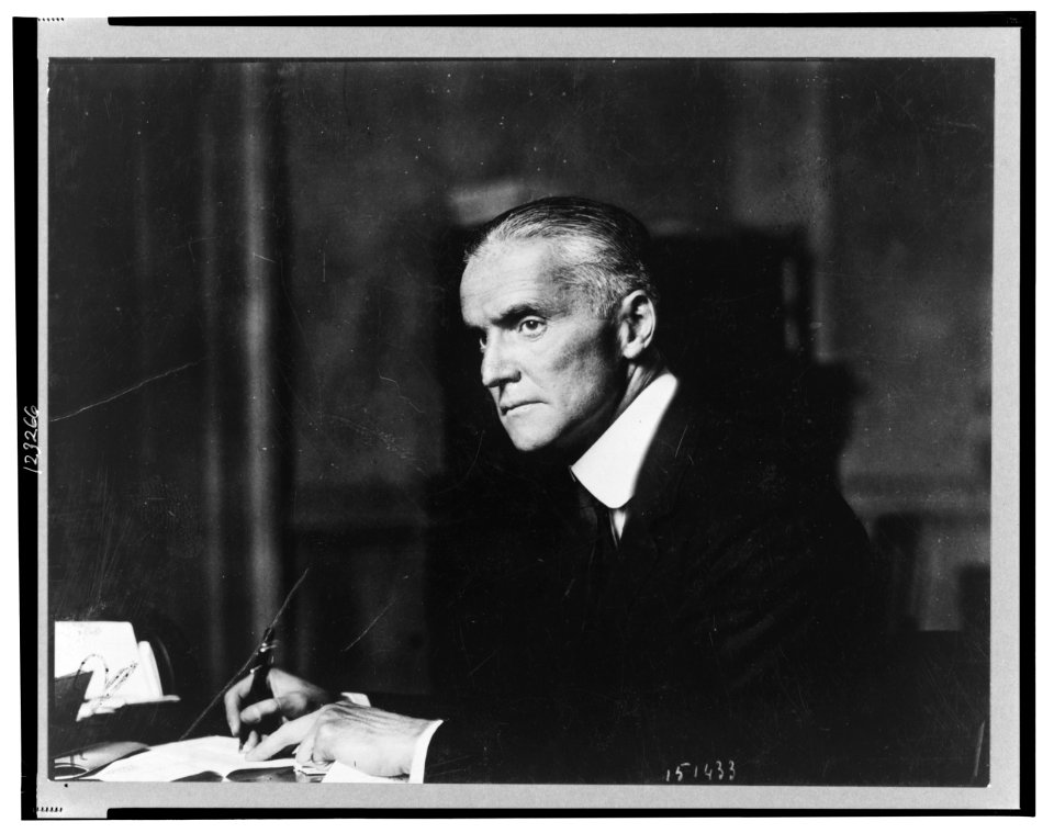 Frank L. Polk, half-length portrait, seated at desk, facing left, holding pen LCCN99404522