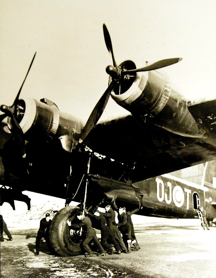 Ground staff pushing a Stirling aircraft for overhaul, 1942-43 (27846331956)
