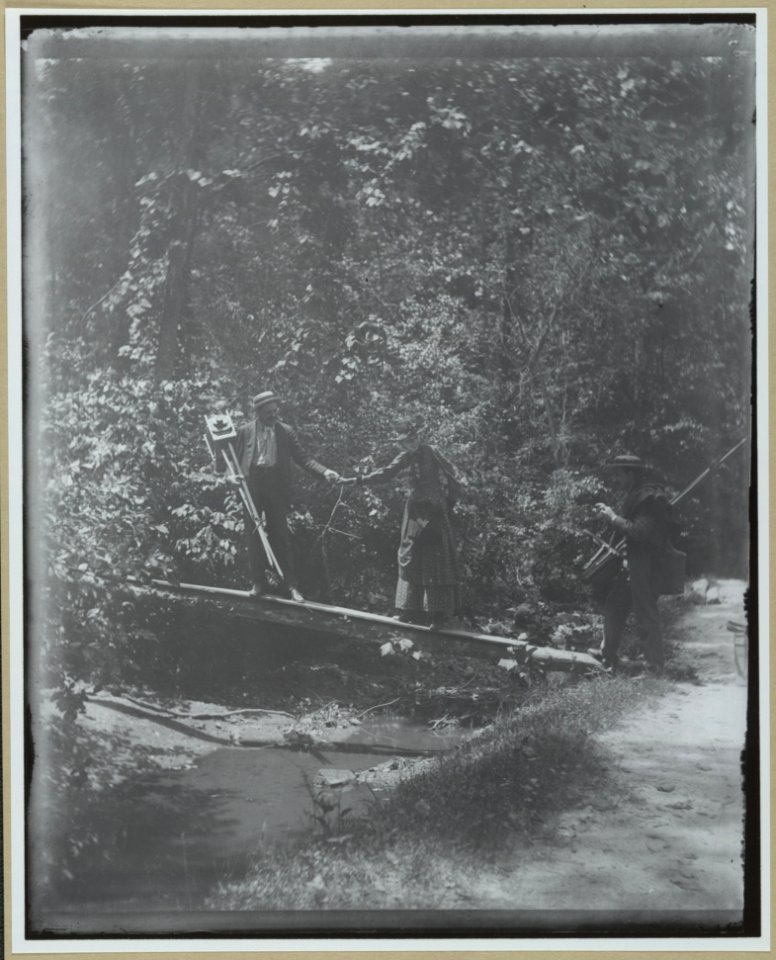 Group crossing footbridge with cameras LCCN2001697162