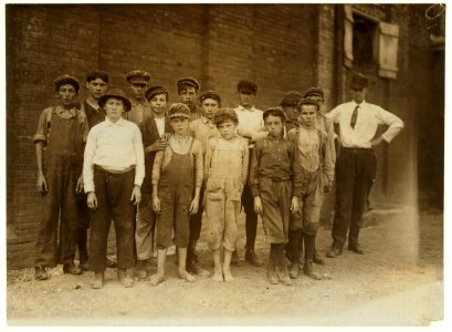 Group of doffers in Pell City Cotton Mill posed by the Overseer. Superintendent of mill is also Mayor of Pell City. LOC nclc.01925