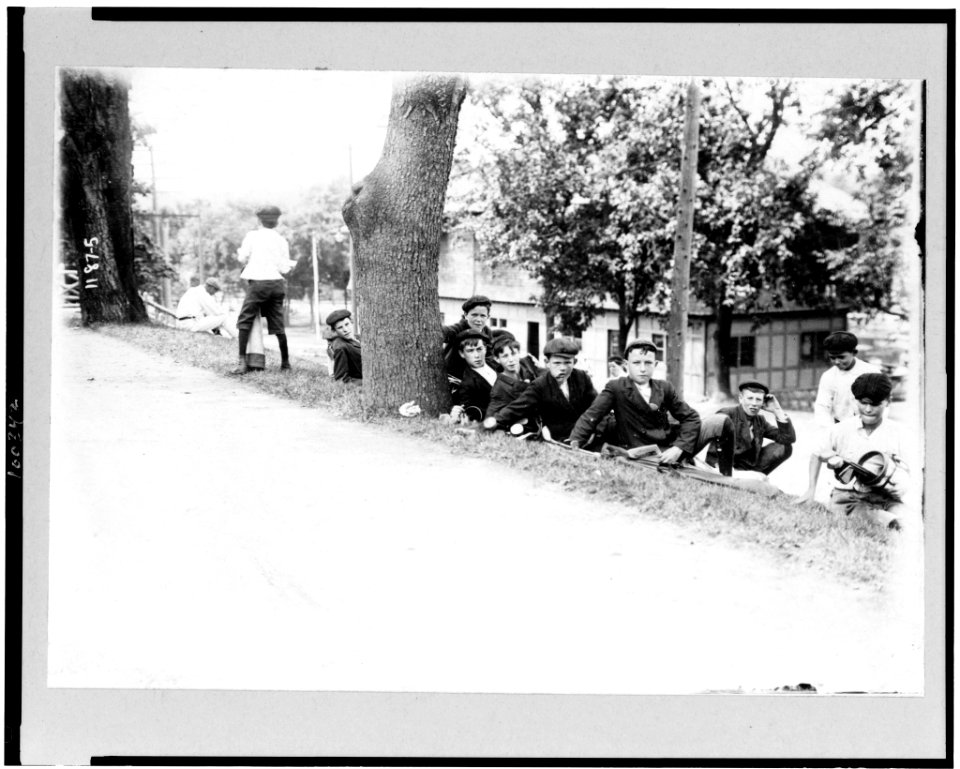 Group of boys with golf clubs-probably caddies-resting on hill LCCN90712026