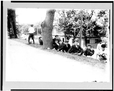 Group of boys with golf clubs-probably caddies-resting on hill LCCN90712026