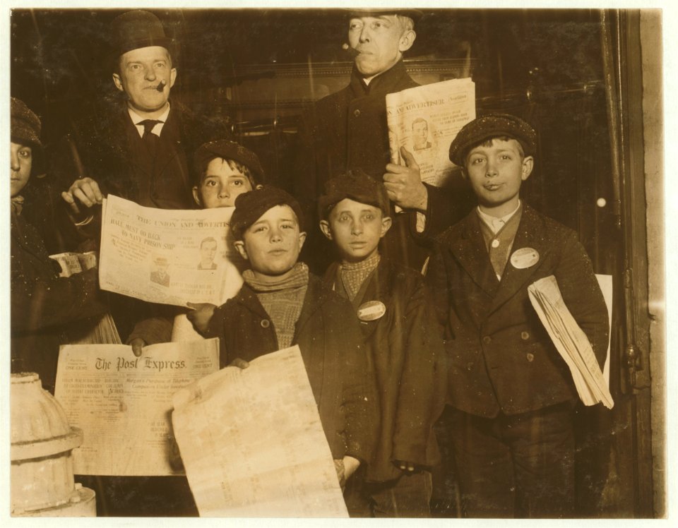 Group of Italian Newsies on South Ave., selling in saloons, and stores. Had just come out of saloon in front of which they are standing. Behind them two typical saloon-patrons who insisted LOC cph.3b39339
