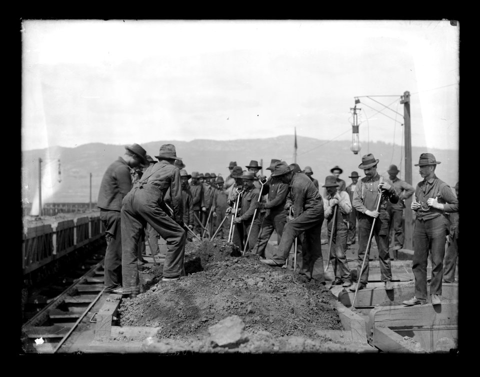Group of laborers digging through dirt pile along railway bed LCCN2016647134