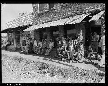 Group of men and boys in front of the post office waiting for the mail. Bokoshe, Le Flore County, Oklahoma. - NARA - 540660 photo