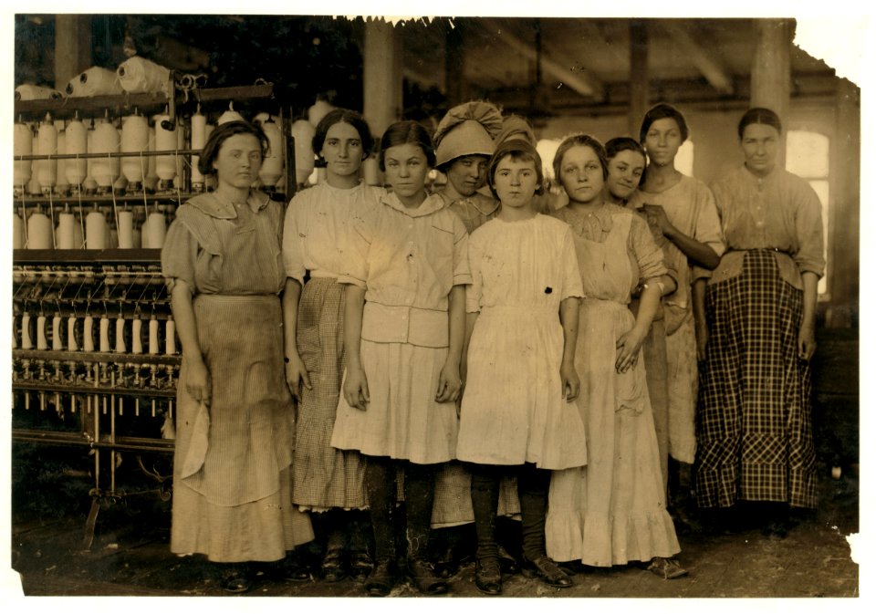 Group of workers in cotton mill at West. Two of them are under legal age. One is twelve and one is fourteen according to their Family Record. Much illiteracy here. LOC nclc.02869