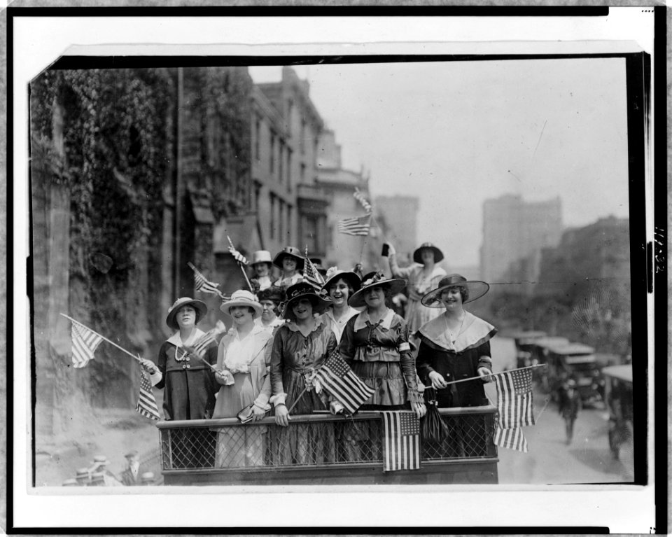 Group of women standing on top of vehicle waving flags, New York City LCCN97511965