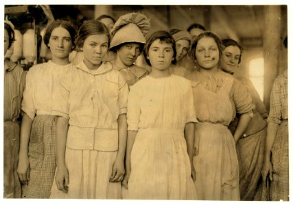 Group of workers in cotton mill at West. Two of them are under legal age. One is twelve and one is fourteen according to their Family Record. Much illiteracy here. LOC nclc.02870 photo