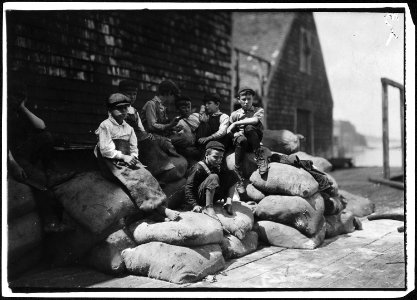 Group of young cutters in a canning factory, waiting for more fish. They all work, but they waste a good deal of time... - NARA - 523453