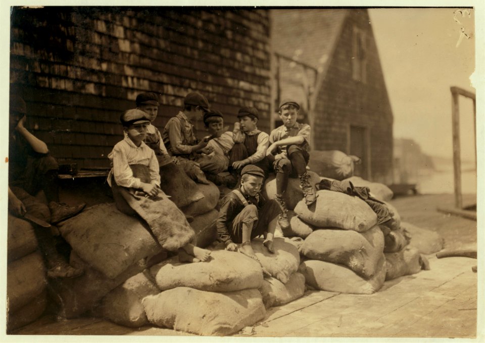 Group of young cutters, Seacoast Canning Co., Factory -2, waiting for more fish. They all work, but they waste a great deal of time as the adults do also, waiting for fish to arrive. LOC cph.3a26040