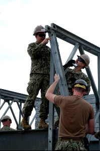 From left, U.S. Navy Builder 1st Class Michael Hoffman, Steelworker 1st Class Patrick Crose and Builder 3rd Class Paul Dishon, all with Naval Mobile Construction Battalion (NMCB) 25, begin deconstruction of 140225-N-JP566-018