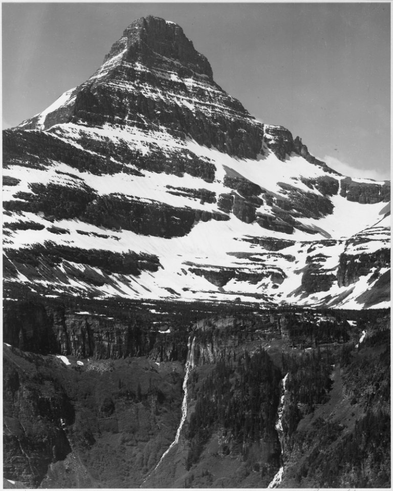 Full view of snow covered mountain, including area below timberline, In Glacier National Park, Montana. (Vertical Orie - NARA - 519872