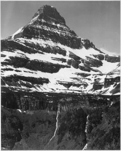 Full view of snow covered mountain, including area below timberline, In Glacier National Park, Montana. (Vertical Orie - NARA - 519872