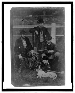 Full-length of four men posed with rifles, hunting dog, and a brace of game birds LCCN2006689560