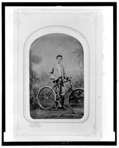 Full-length portrait of a young man standing next to a bicycle LCCN2006689595