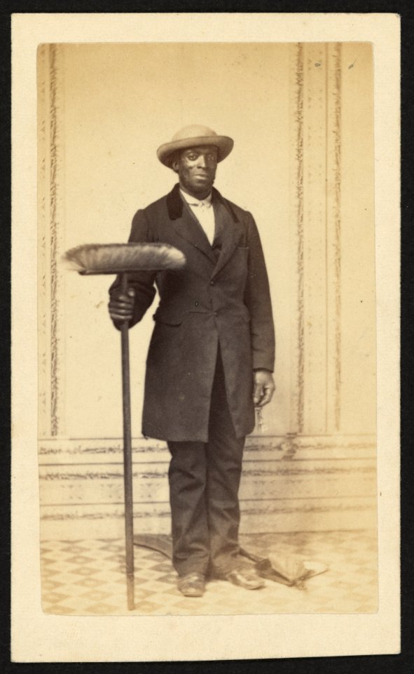 Full-length portrait of an African American man holding a broom LCCN2010647825