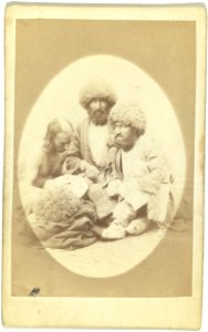 Full-length portrait of three men, seated on ground, facing front LCCN99615633