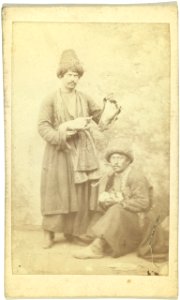 Full-length portrait of two men, one seated, one standing, facing front LCCN99615606