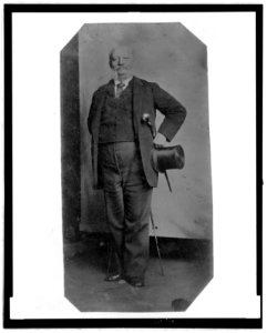 Full-length portrait of a man holding a top hat and walking stick LCCN2006689575