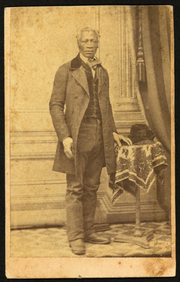 Full-length portrait of unidentified African American man in suit, standing next to a table) - Whiddit & Coffin, Photographers, 82 Water Street, Newburgh, N.Y LCCN2010647815