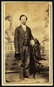 Full-length portrait of an unidentified African American man standing beside a chair) - Mrs. R. Geer, Photographer, Jackson, Mich LCCN2010647812