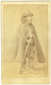 Full-length portrait of man wearing cloak and holding rifle LCCN99615607