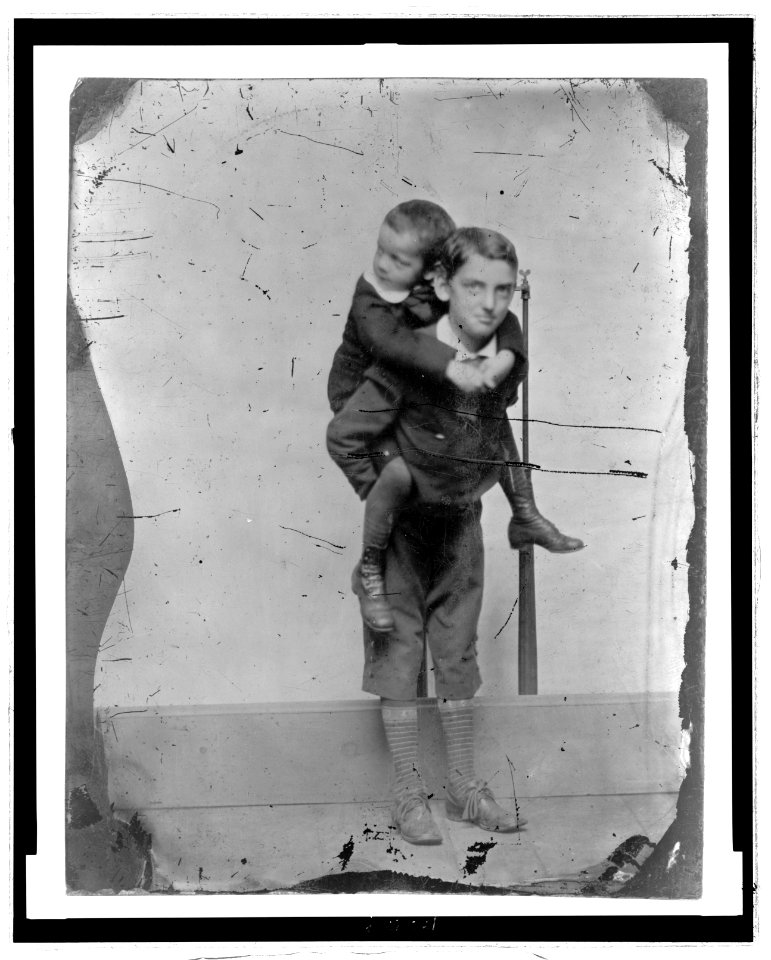 Full-length portrait two boys, the older one carrying the younger on his back LCCN2006689559