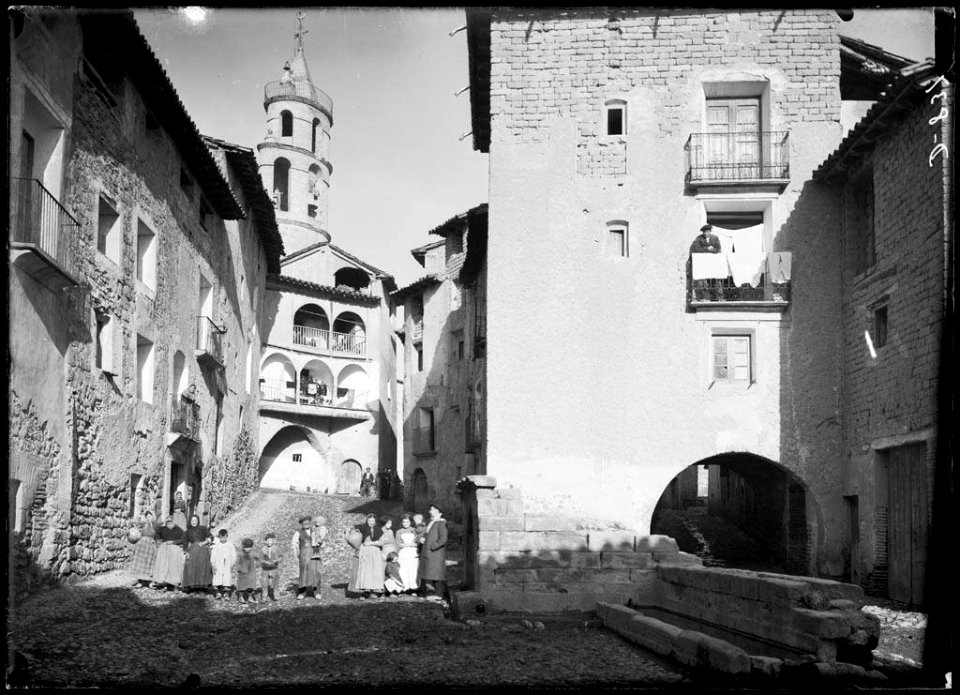 Grup de persones al carrer de la Font de Torres del Obispo amb un porxo