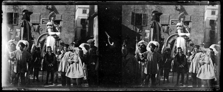 Grup de nens davant dels capgrossos i els gegants de Barcelona en cercavila