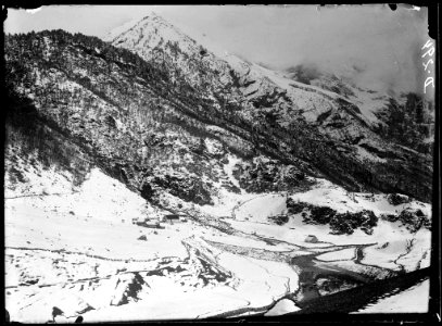 Grup de cases i riu en una vall nevada voltada de boscos