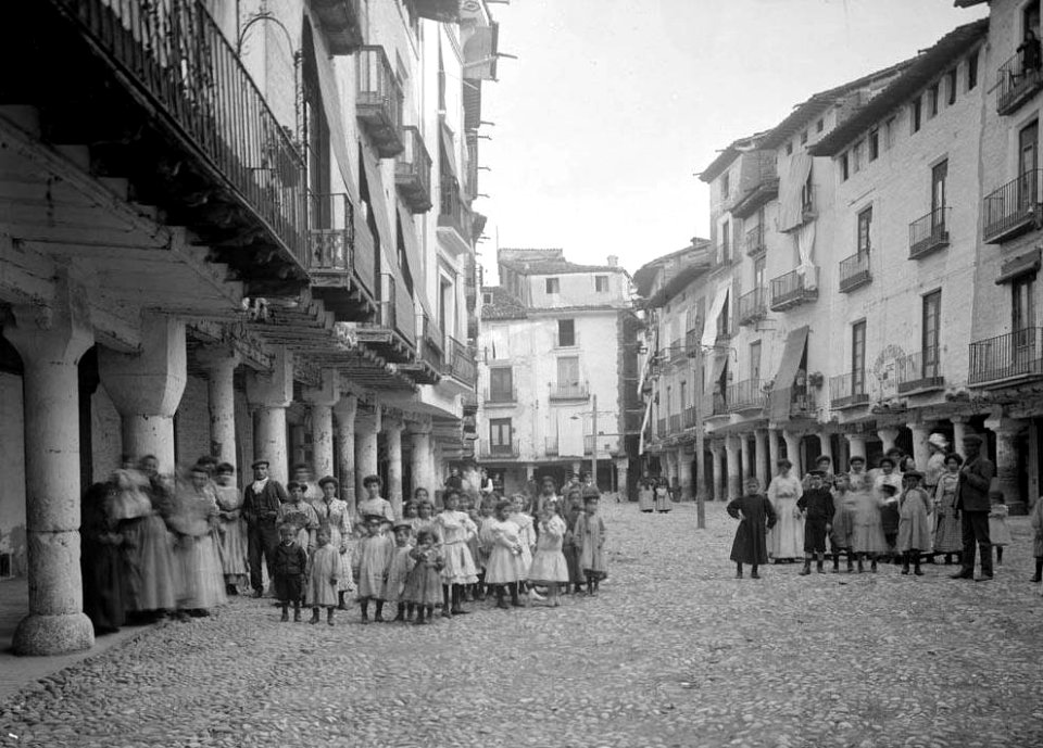 Grups de persones, la majoria infants, a la plaça major porxada de Barbastre (cropped)