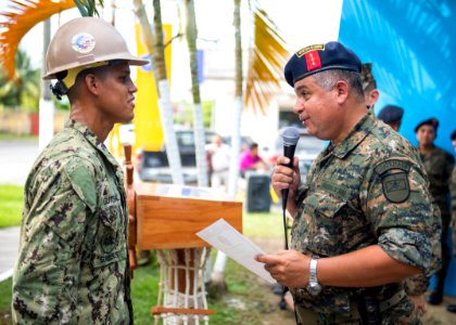 Guatemalan Navy Capt. Saul Arnoldo Tobar Garcia, right, gives a certificate of appreciation to U.S. Navy Builder 2nd Class Jeremy Gutshall, assigned to Construction Battalion Maintenance Unit 202, during 140821-N-XQ474-210