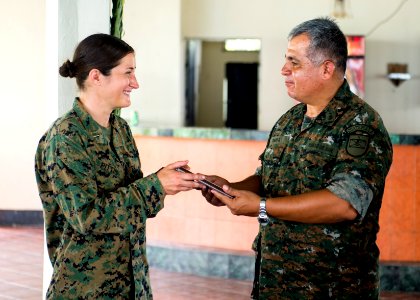 Guatemalan Ship's Capt. Saul Arnoldo Tobar Garcia, right, the second in command of the Guatemalan Marine Brigade, presents a gift of appreciation to U.S. Marine Corps Capt. Annie Pittis during a Southern 140822-N-XQ474-217