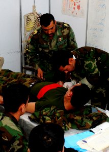 Instructor looks on as Afghan soldiers practice administering an IV (4510289652)