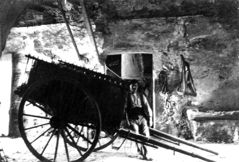 Interior de Cal Arnan amb un home i un carro