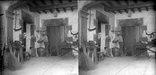 Interior de la masia el Solà amb estris diversos , un home i un nen