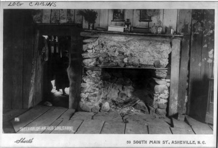 Interior of an old log cabin, shows fireplace and a child holding a smaller child inside doorway of an adjoining room LCCN2006683529