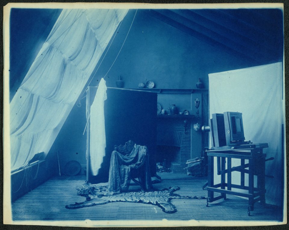 Interior of Frances Benjamin Johnston's studio at 1332 V St. NW, Washington, D.C., showing a large camera and props arranged for a portrait LCCN2001697176