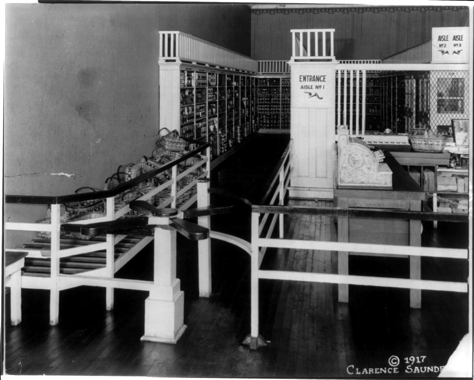 Interior of Piggly Wiggly store, Tenn., showing entrance turnstile with small wicker shopping baskets, and check-out counter; 1st self-service grocery store in U.S. LCCN2004676518