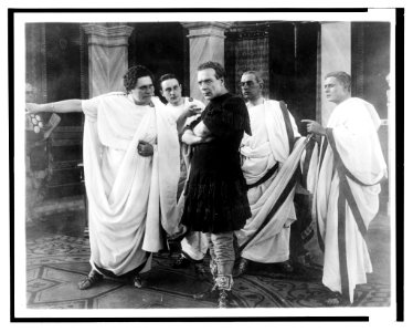Interior scene, Novelli (Julius Caesar) in center in black coat surrounded by four senators ... LCCN2003675554